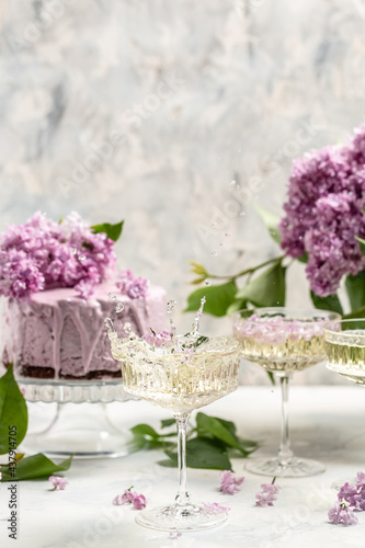 prosecco, champagne, wine and blueberry tart with bouquet of purple blooming lilacs, postcard, background. vertical image place for text