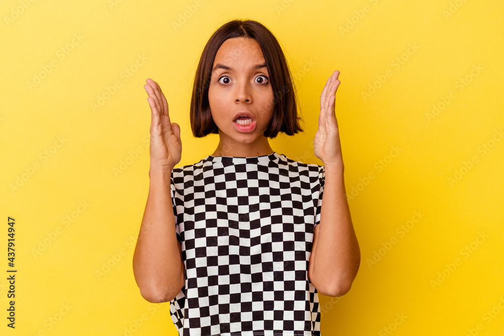 Young mixed race woman isolated on yellow background surprised and shocked. Young mixed race woman isolated on yellow background surprised and shocked.