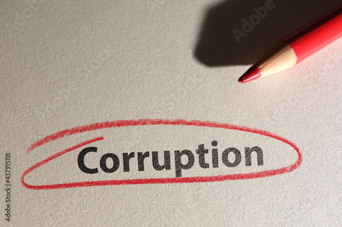 Corruption text circled in red pencil on texured paper photo