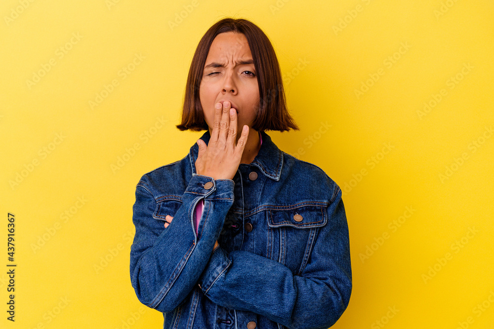 Young mixed race woman isolated on yellow background yawning showing a tired gesture covering mouth with hand. Young mixed race woman isolated on yellow background yawning showing a tired gesture covering mouth with hand.