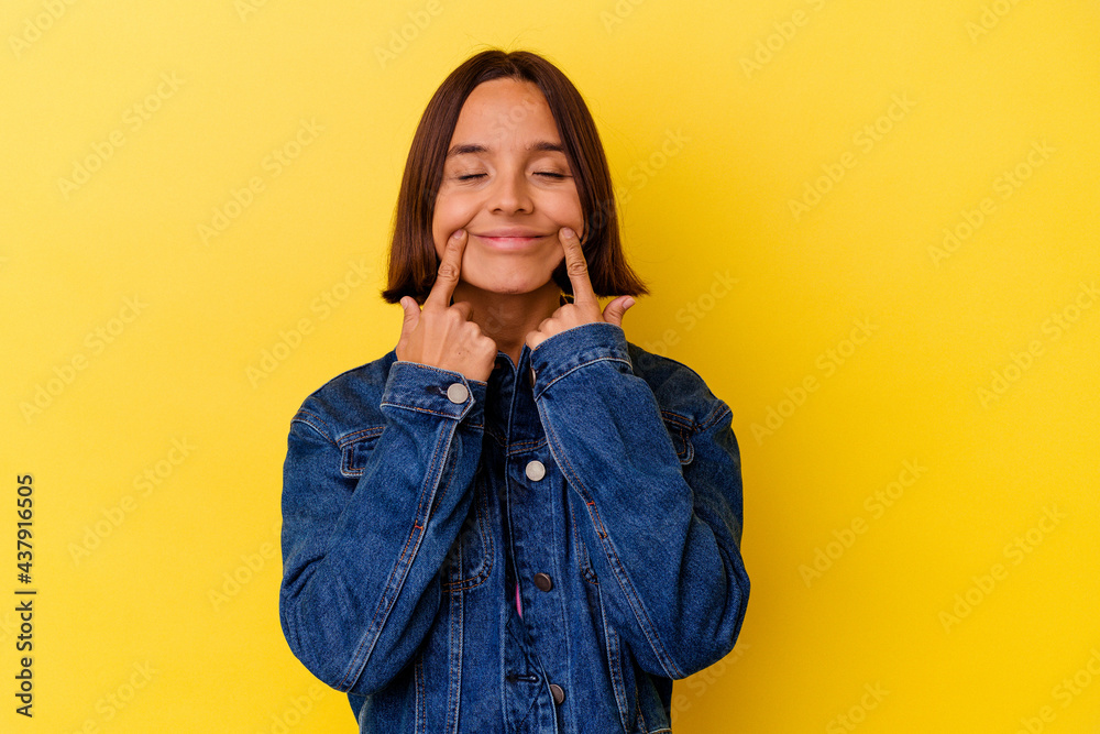 Young mixed race woman isolated on yellow background doubting between two options. Young mixed race woman isolated on yellow background doubting between two options.