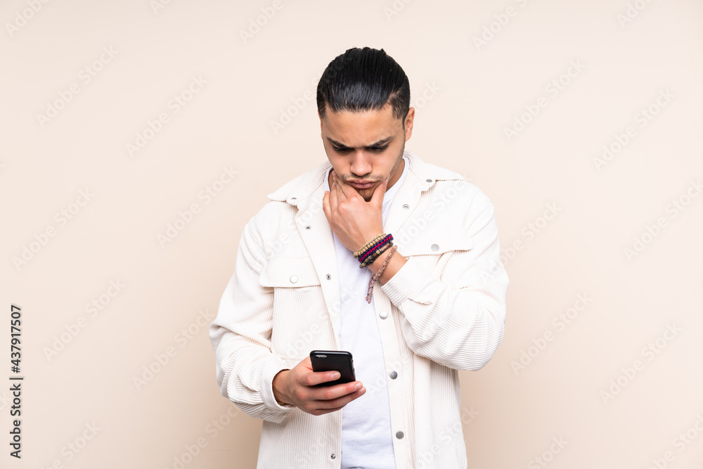 Asian handsome man over isolated background thinking and sending a message Asian handsome man over isolated background thinking and sending a message