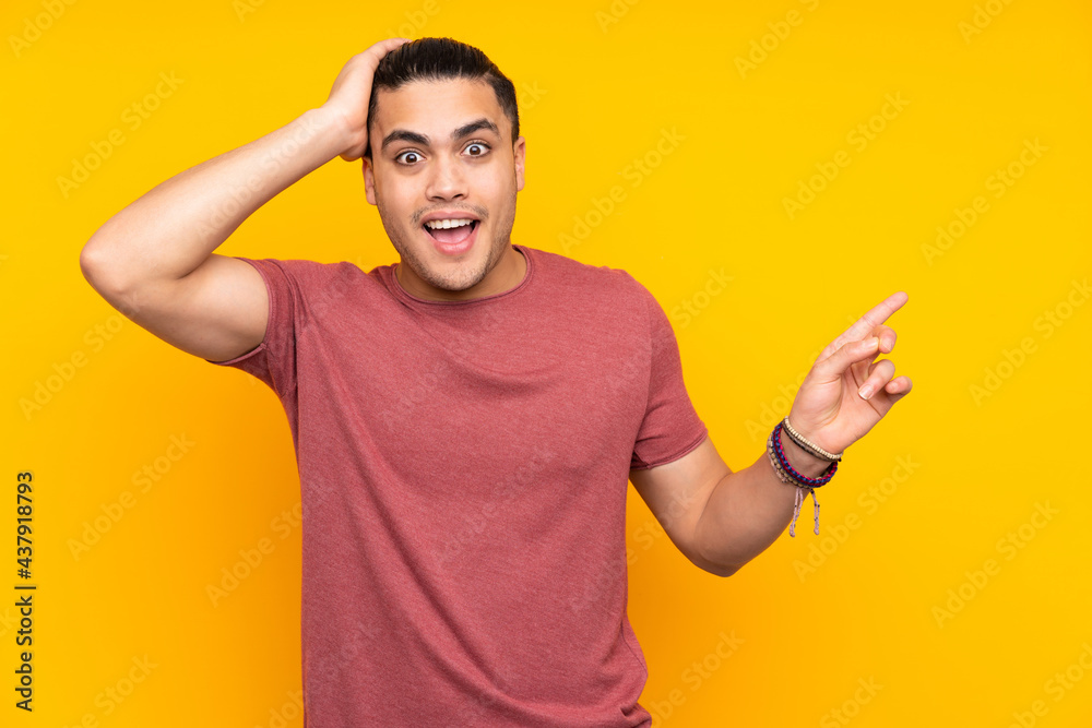 Asian handsome man isolated on yellow background pointing to the side to present a product Asian handsome man isolated on yellow background pointing to the side to present a product