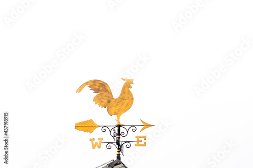 Gold rooster weather vane show the wind direction on white sky background photo