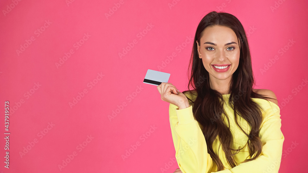 happy young adult woman holding credit card isolated on pink happy young adult woman holding credit card isolated on pink