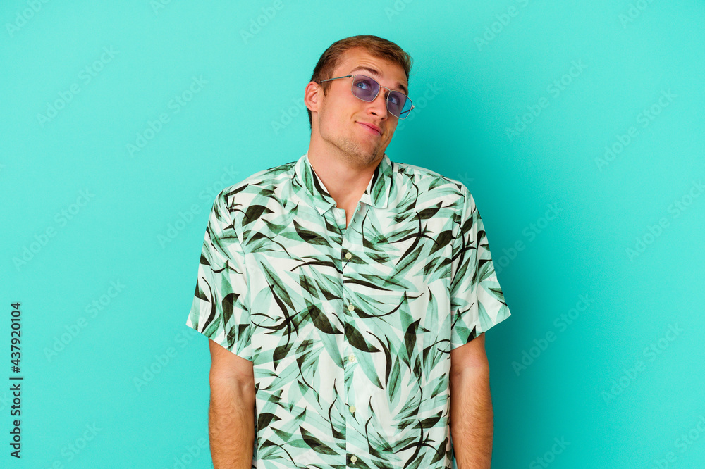 Young caucasian man wearing a summer clothes isolated on blue background Young caucasian man wearing a summer clothes isolated on blue background