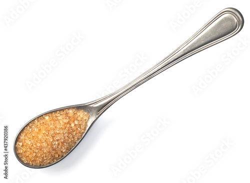 yellow sugar in the silver spoon, isolated on white background, top view