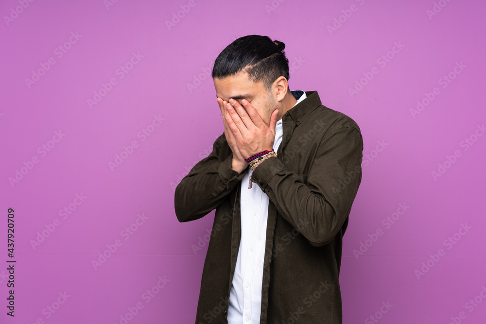 Asian handsome man isolated on blue background with tired and sick expression Asian handsome man isolated on blue background with tired and sick expression