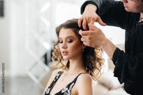 In a beautiful, modern beauty salon, a professional stylist makes a haircut and hairstyle for a young girl. Beauty, and fashion