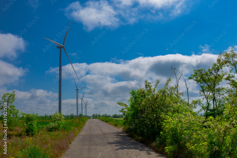 wind turbine on a bright sunny day against the backdrop of a cloudy sky