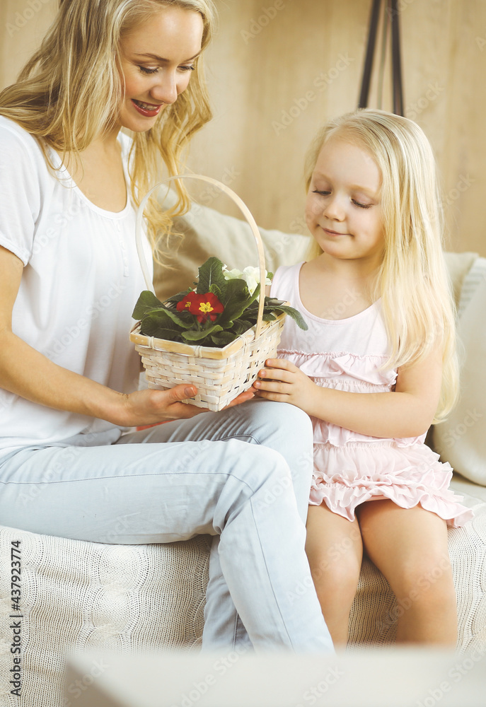 Happy mother day. Child daughter congratulates mom and gives her basket of spring flowers. Family and childhood concepts