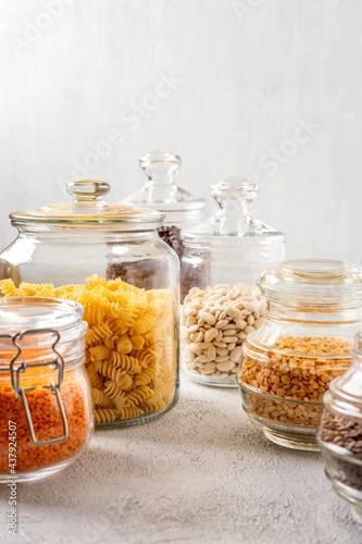 Different legumes in glass jars: chickpeas, pasta, beans, peas, lentils. Zero waste storage, plastic free.