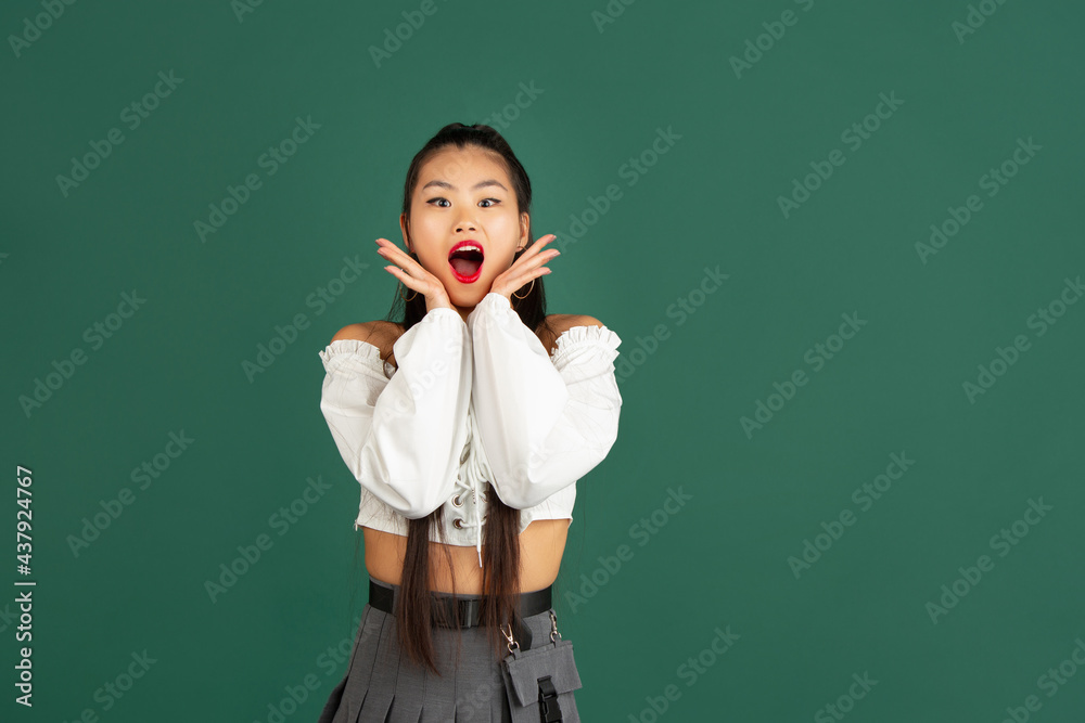 Wow. Beautiful female half-length portrait isolated on studio backgroud. Young emotional surprised woman standing with open mouth.