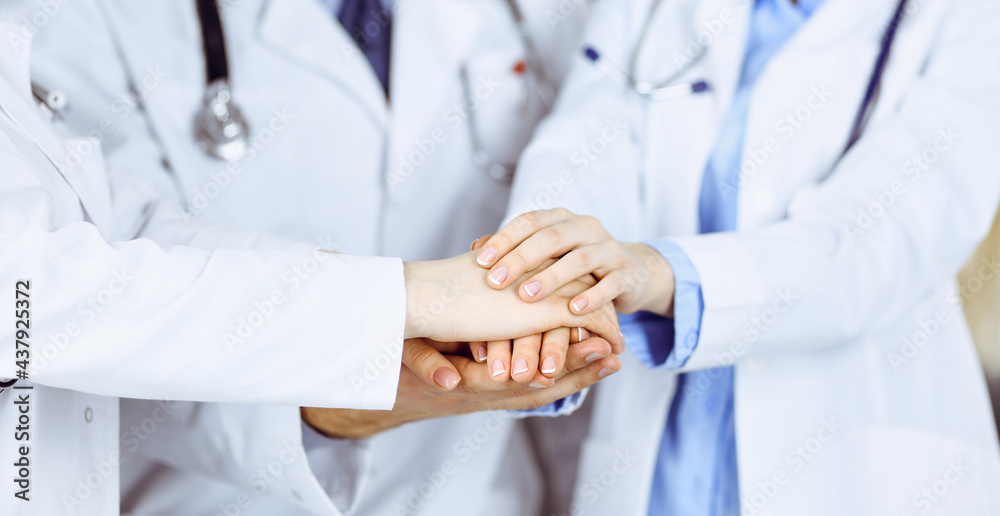 Group of modern doctors joining hands as a circle and ready to help patients. Teamwork in medicine during Coronavirus pandemic. Covid 2019 Group of modern doctors joining hands as a circle and ready to help patients. Teamwork in medicine during Coronavirus pandemic. Covid 2019