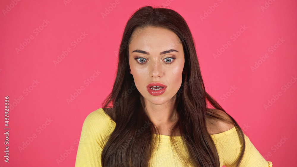 scared young adult woman in yellow blouse isolated on pink scared young adult woman in yellow blouse isolated on pink