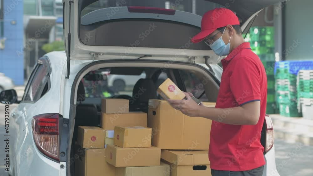 Business concept of 4k Resolution. The delivery worker checks the package inside the car. Business concept of 4k Resolution. The delivery worker checks the package inside the car.
