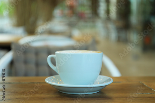 Cup of coffee on wooden table in restaurant