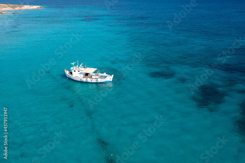 Greece, Cyclades. Aerial drone view of a fishing boat on turquoise color sea water © Rawf8