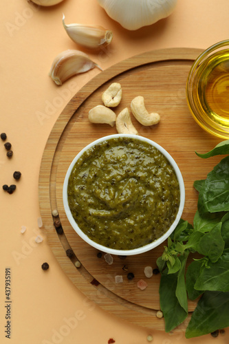 Pesto sauce and ingredients for cooking on beige background