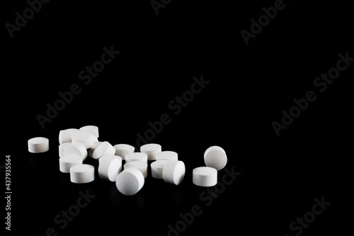 Small group of white pills isolated on black background