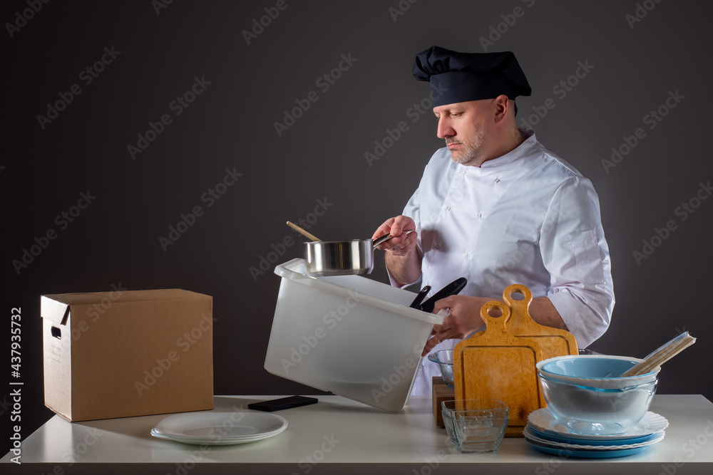 Chef takes out kitchen utensils from the box. Chef is holding a plastic