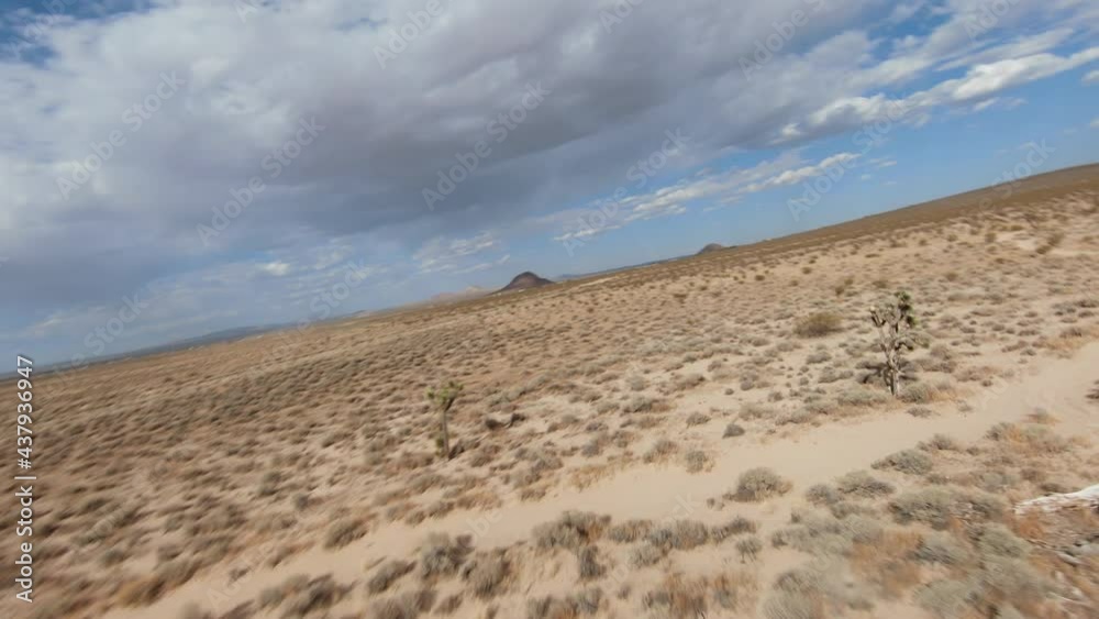 A fast low altitude flight over the Mojave Desert with tight turns that tilt the horizon - first person aerial view