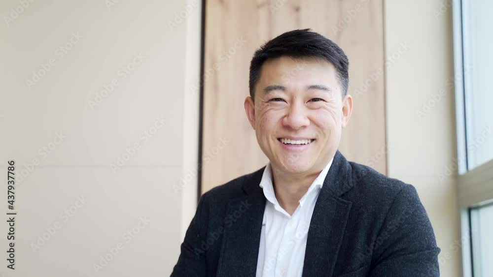 portrait of happy young asian male office worker looking at camera and smiling indoors. Close up of a friendly manager in a formal suit and white shirt sitting at work. business man feeling receiving portrait of happy young asian male office worker looking at camera and smiling indoors. Close up of a friendly manager in a formal suit and white shirt sitting at work. business man feeling receiving