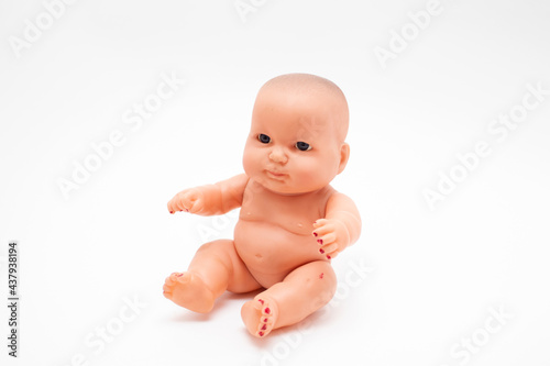 Cute little baby doll sitting on white background