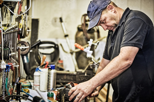 Middle-aged man working in his repair shop.