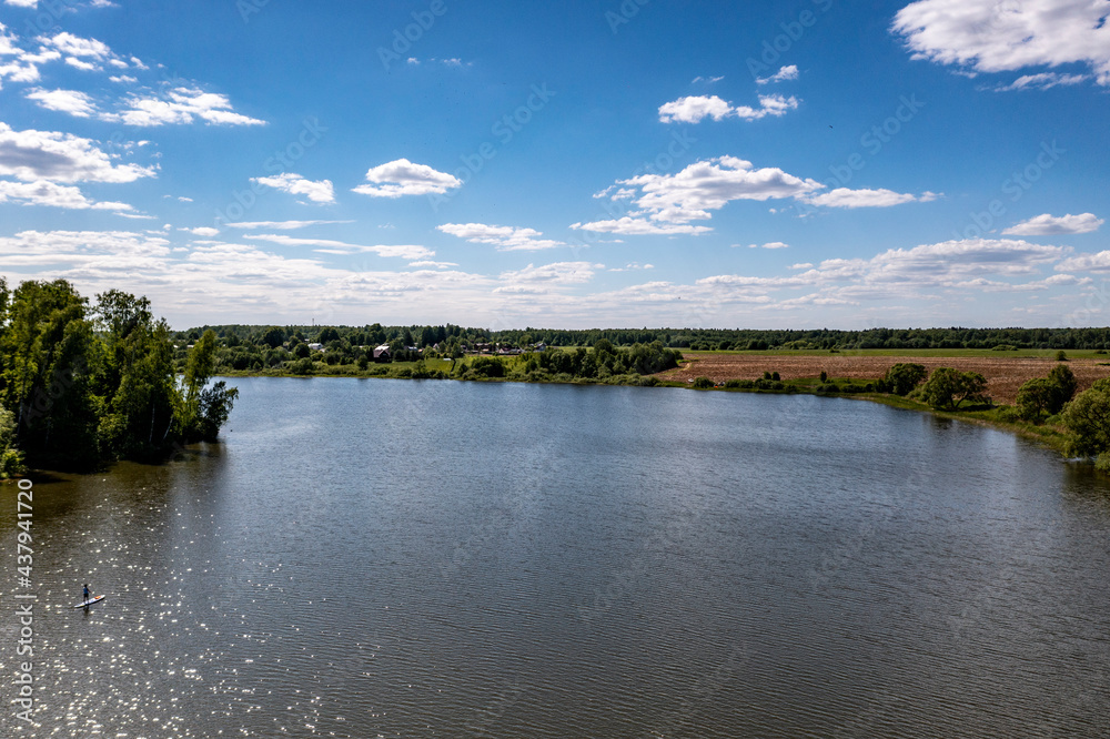 panoramic view from the drone to the village of a large lake and forest and fields and roads 