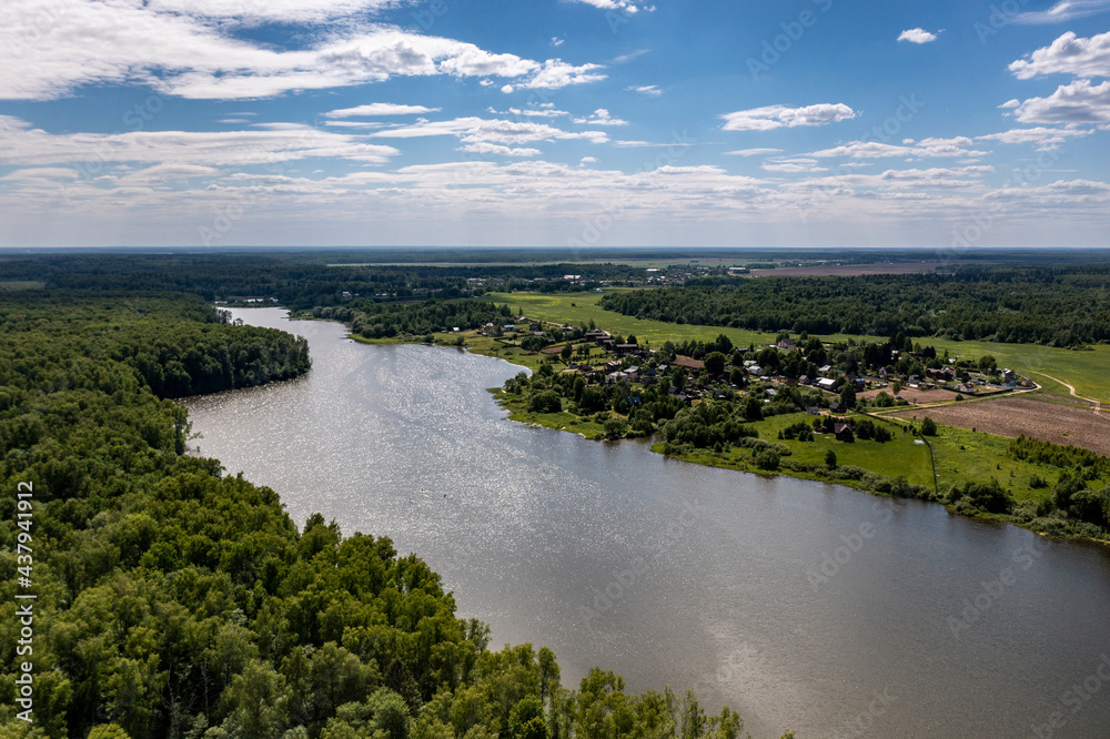 panoramic view from the drone to the village of a large lake and forest and fields and roads 