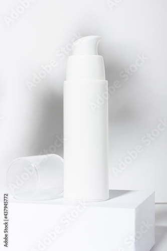 White cosmetic tube for cream, lotion, serum or face mask on the runway with leaf shadows. Professional cosmetics for skin care. Organic cosmetics.