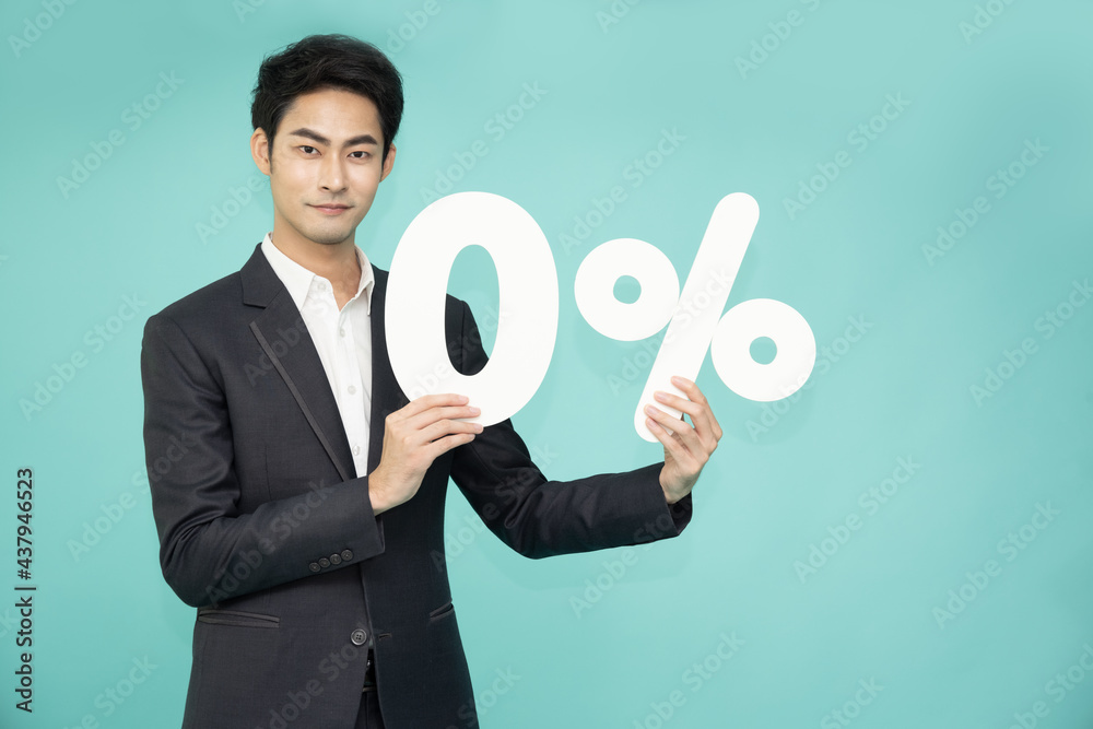 Portrait of Asian business man showing and holding 0% number or zero percent isolated over green background Portrait of Asian business man showing and holding 0% number or zero percent isolated over green background