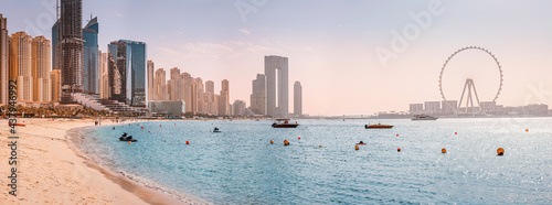 Panoramic views of the Persian Gulf beach and Bluewaters Island with the worlds famous largest Ferris wheel Dubai Eye and numerous skyscrapers with hotels and residences