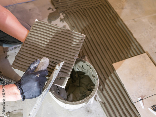 Applying thinset mortar on a tile. Apply the adhesive, closeup.