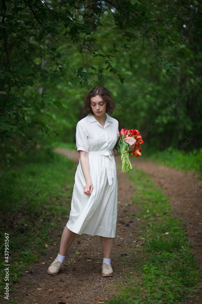 beautiful young girl walks in the garden with a bouquet of tulips, brunette in a body dress. Bouquet of tulips. Spring time. beautiful young girl walks in the garden with a bouquet of tulips, brunette in a body dress. Bouquet of tulips. Spring time.