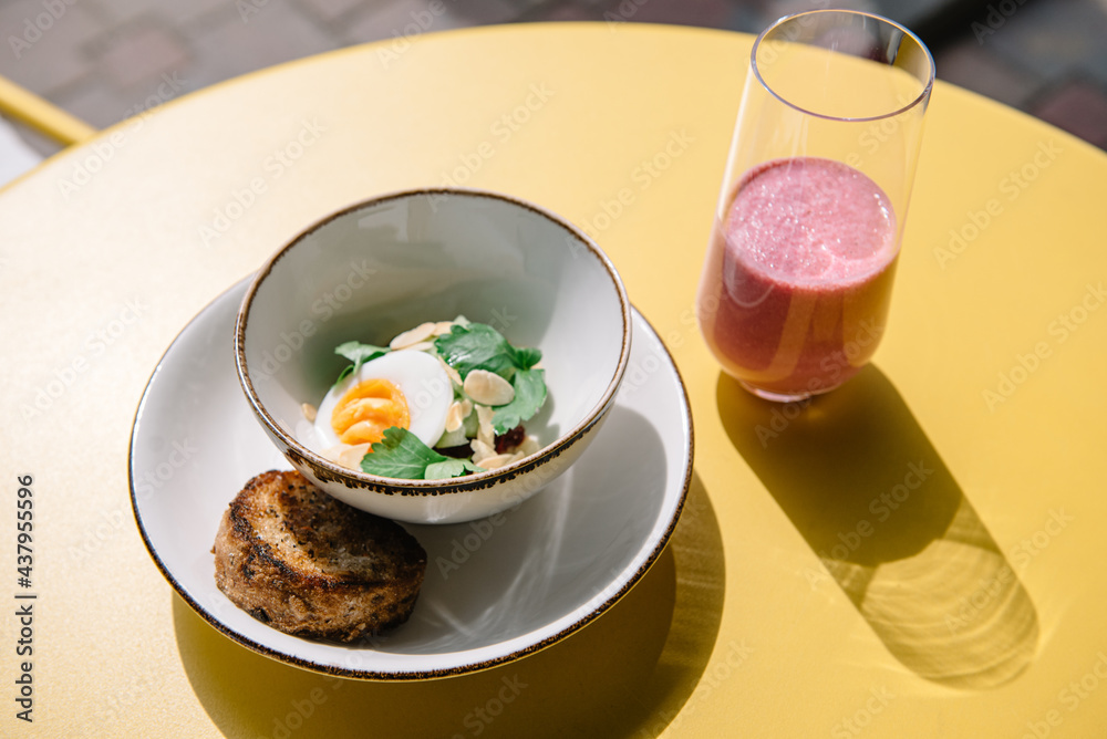 cold beet soup with kefir, fresh herbs, boiled egg and slice of grilled bread on the table of cafe summer terrace cold beet soup with kefir, fresh herbs, boiled egg and slice of grilled bread on the table of cafe summer terrace