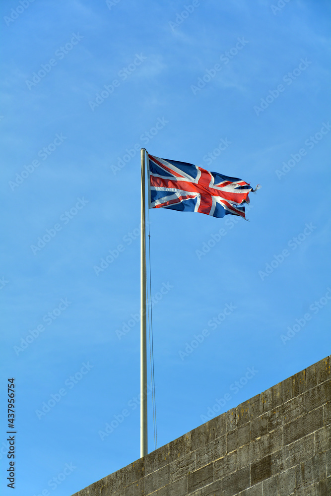 British Union Jack flag flying over a building against a blue sky