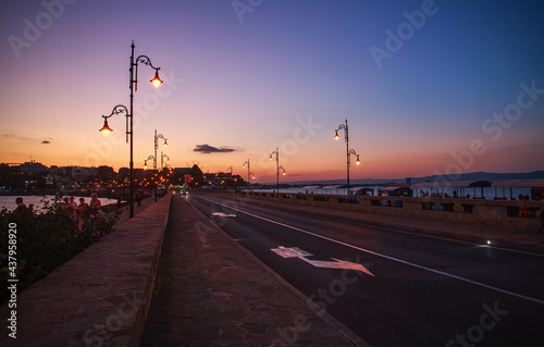 Asphalt road in sea bay leading to old town of Nessebar  Bulgaria  on background of colorful sky