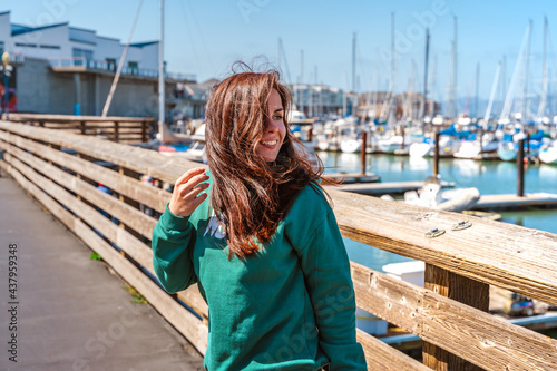 Canvas Print A young woman stands on pier 39 leaning on a fence, San Francisco