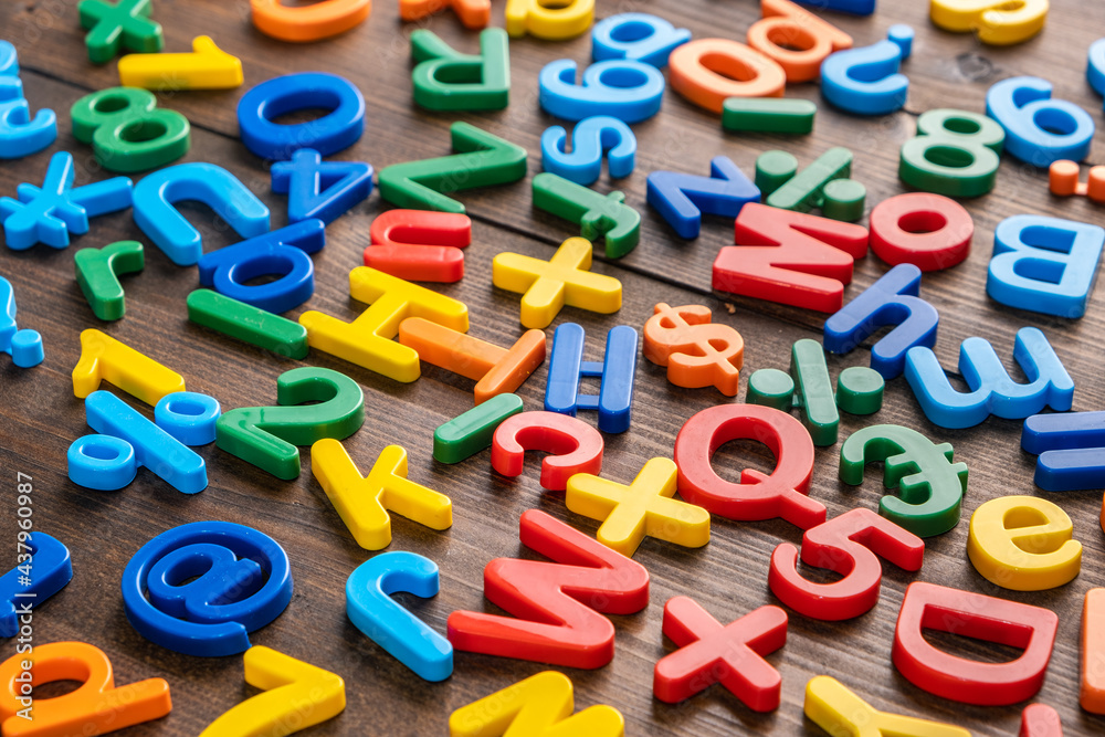 Top view of colorful plastic letters and numbers on wooden background Top view of colorful plastic letters and numbers on wooden background