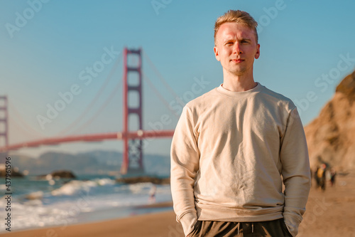 A young man walks on the beach overlooking the Golden Gate Bridge in San Francisco, USA