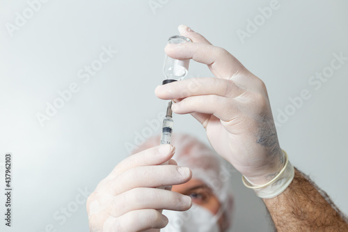 Médico preparando uma seringa com vacina em primeiro plano. photo