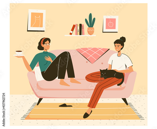 Friendship concept. Two girlfriends talking sitting on sofa at home