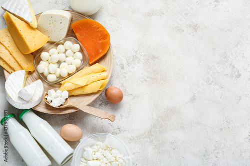 Different dairy products and chicken eggs on light background