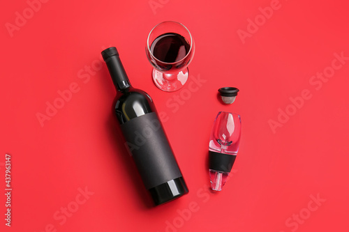 Bottle of wine, glass and aerator on color background photo