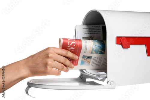 Woman putting newspaper in ...