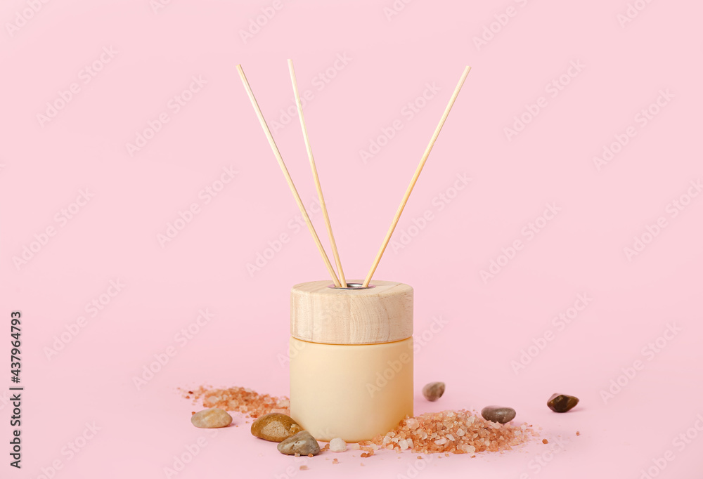 Reed diffuser with sea salt and stones on color background Reed diffuser with sea salt and stones on color background