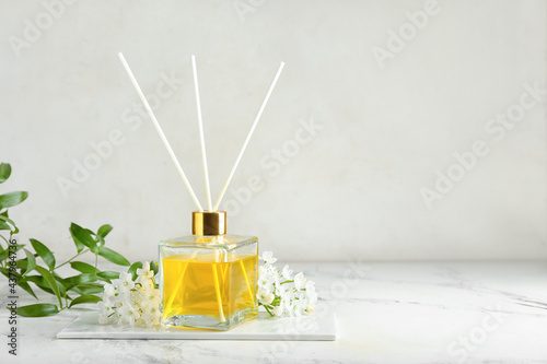 Reed diffuser with jasmine on light background