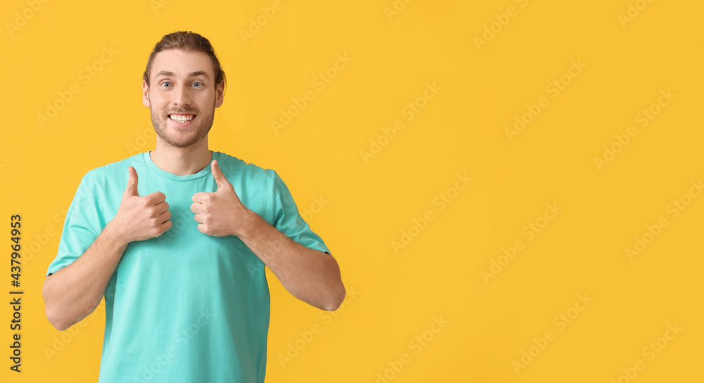 Handsome man showing thumbs-up on color background Handsome man showing thumbs-up on color background